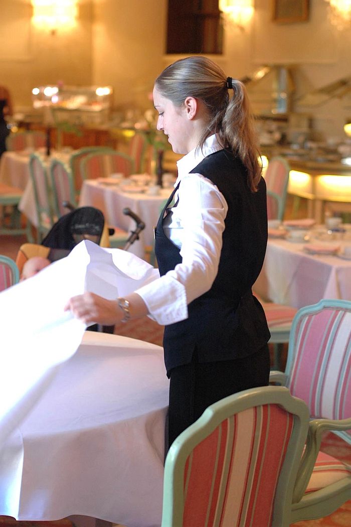 Kellnerin deckt Tisch ein - Reiner Pfister - Dehoga